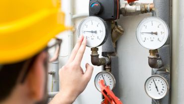 A person is checking the pressure of an industrial device.