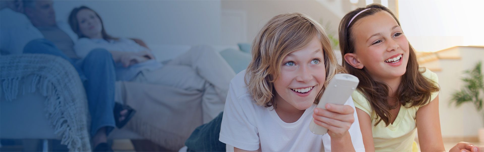 A woman is smiling while holding her phone.